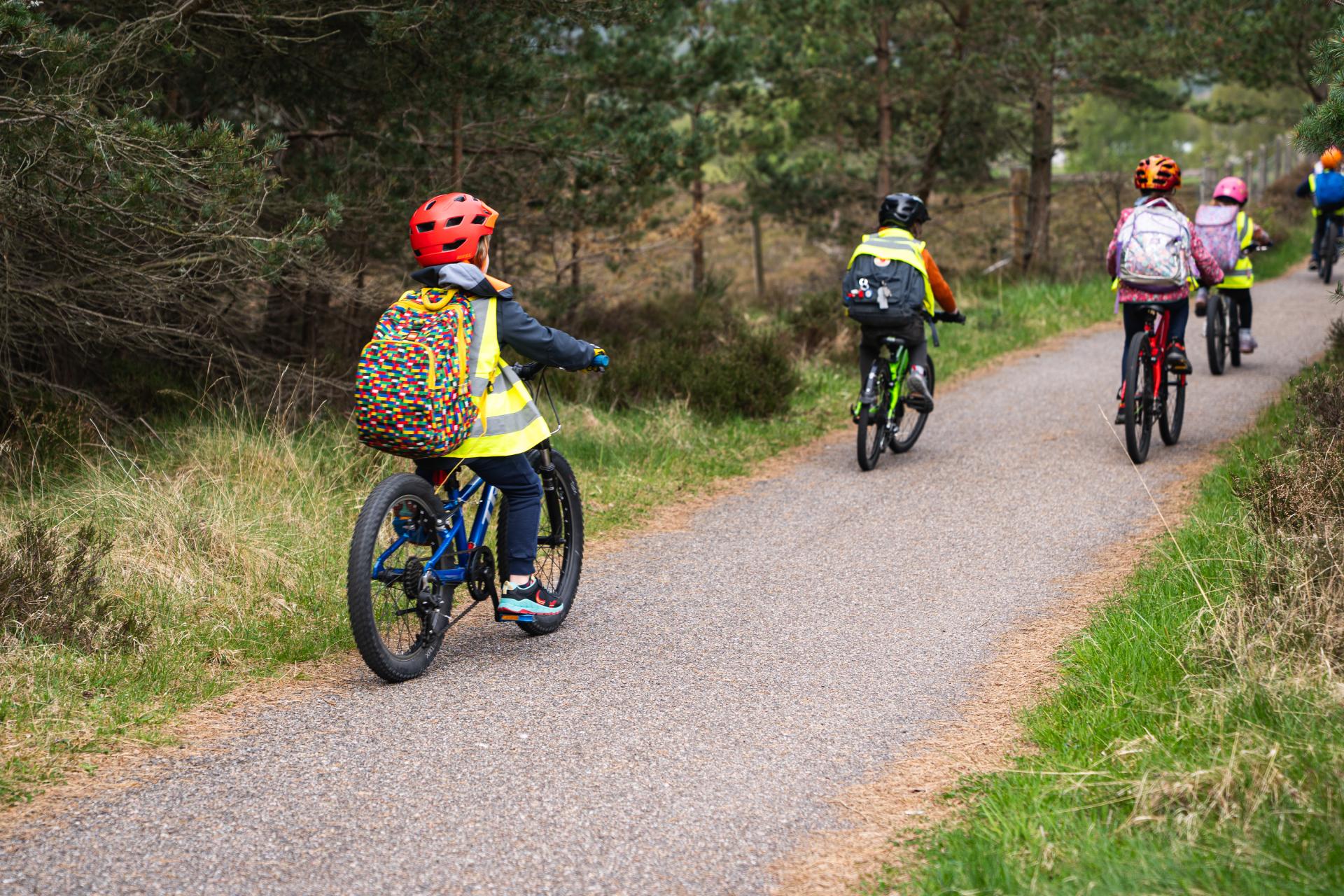Children riding bikes on bike path in the woods