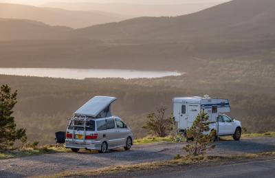 Two motorhome vehicles parked at sunset