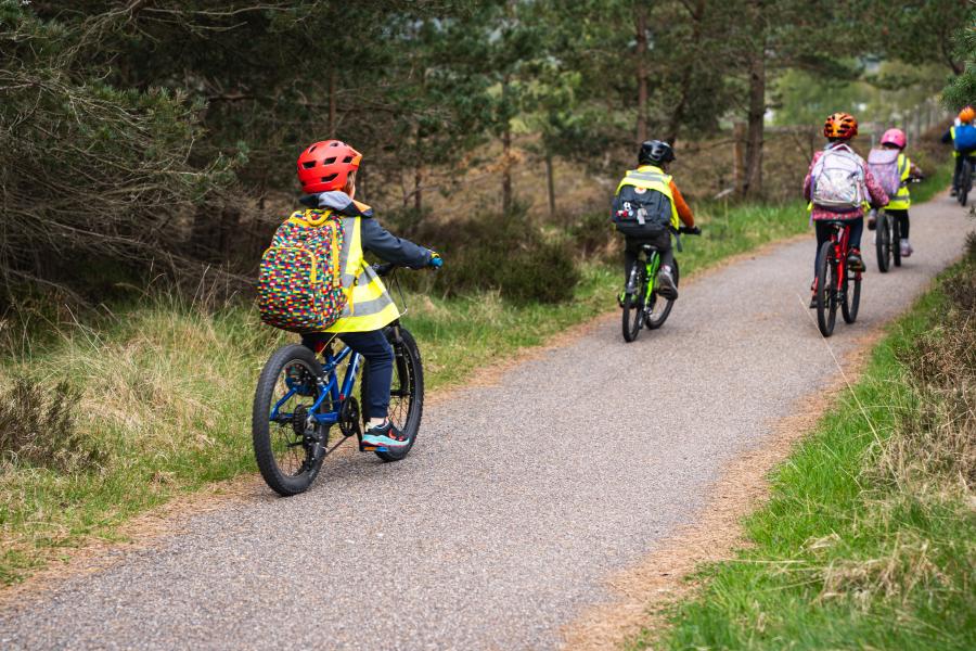 Children riding bikes on bike path in the woods