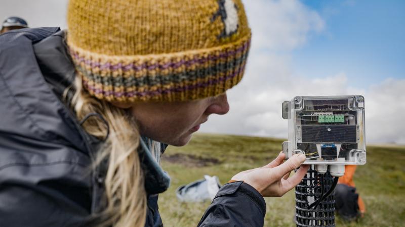 Member of the peatland team setting up monitoring equipment.