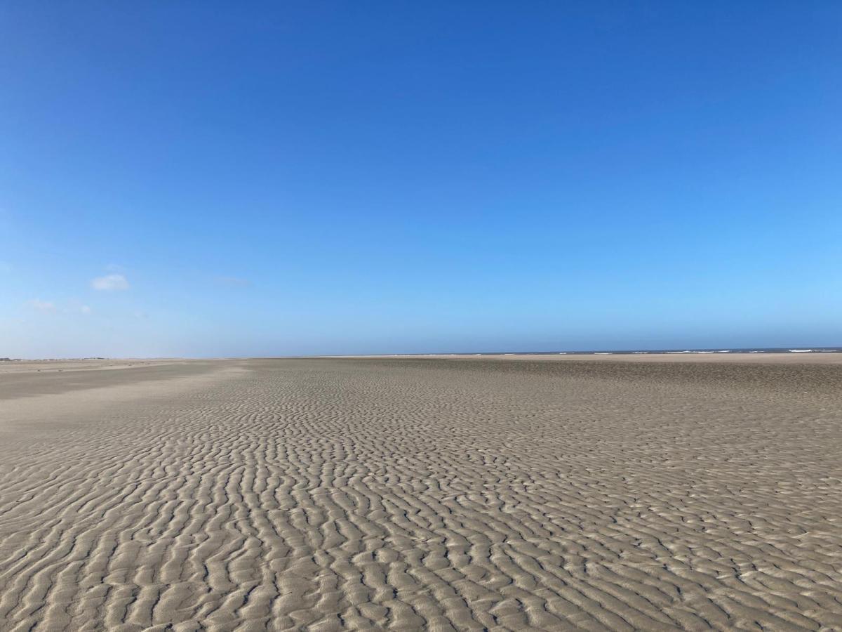 Flat sandy landscape with blue skies.