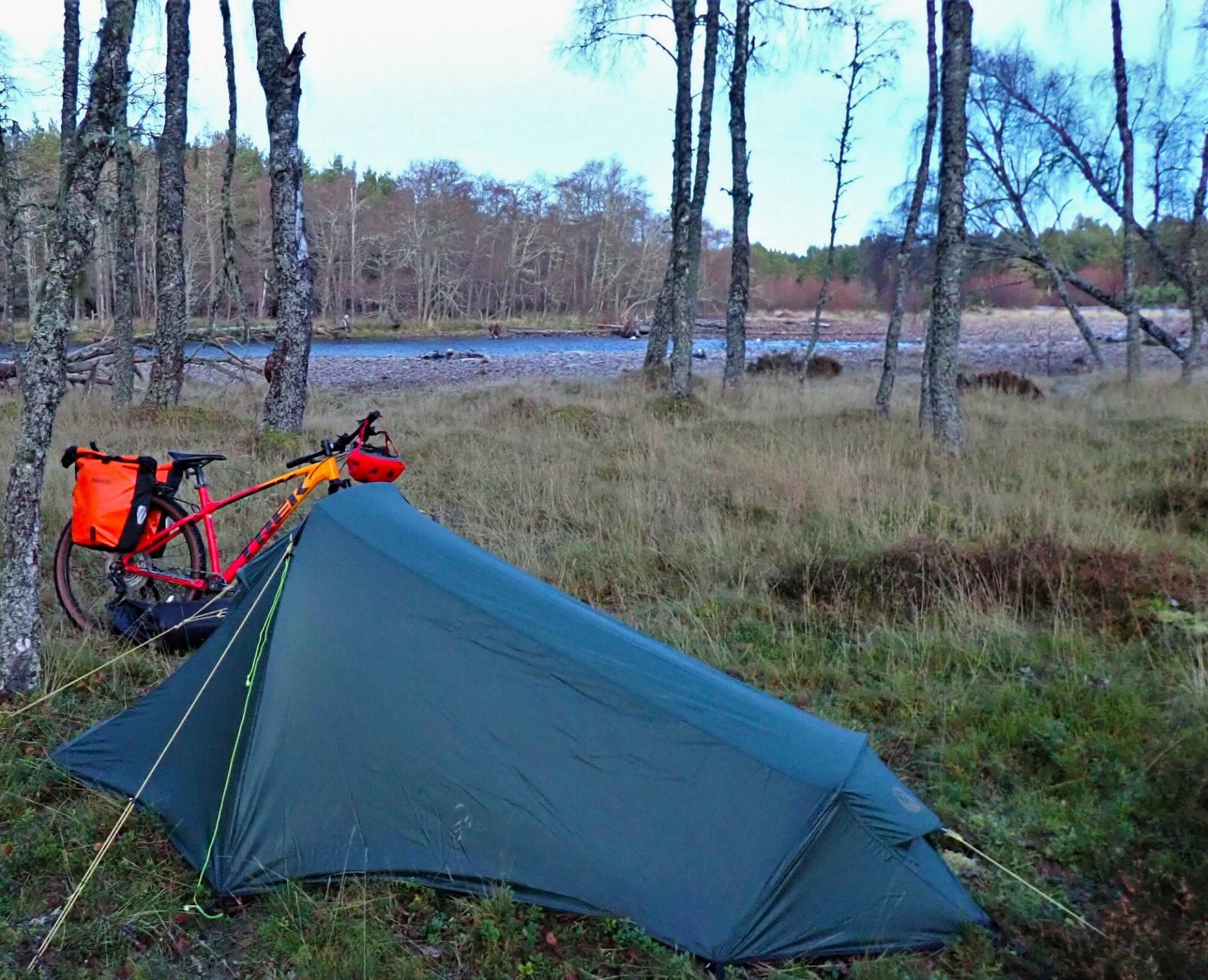 Bike and tent amongst trees, near the River Dulnain.