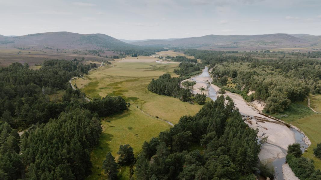 Aerial view of Slugain Burn and the River Dulnain with fields and forests.