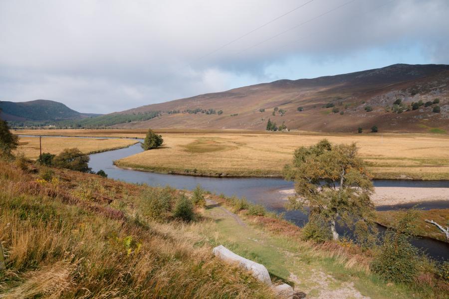 View across the River Dee and floodplain beyond with hills in background.