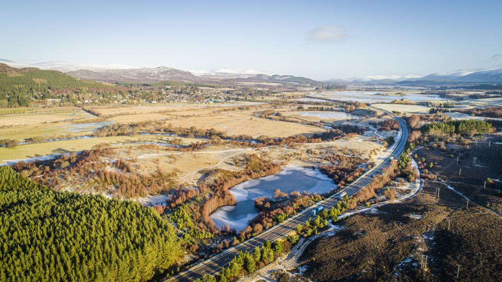 Aerial view of Lochan an Tairbh, near Ruthven, and next to the A9, with Kingussie in the background.