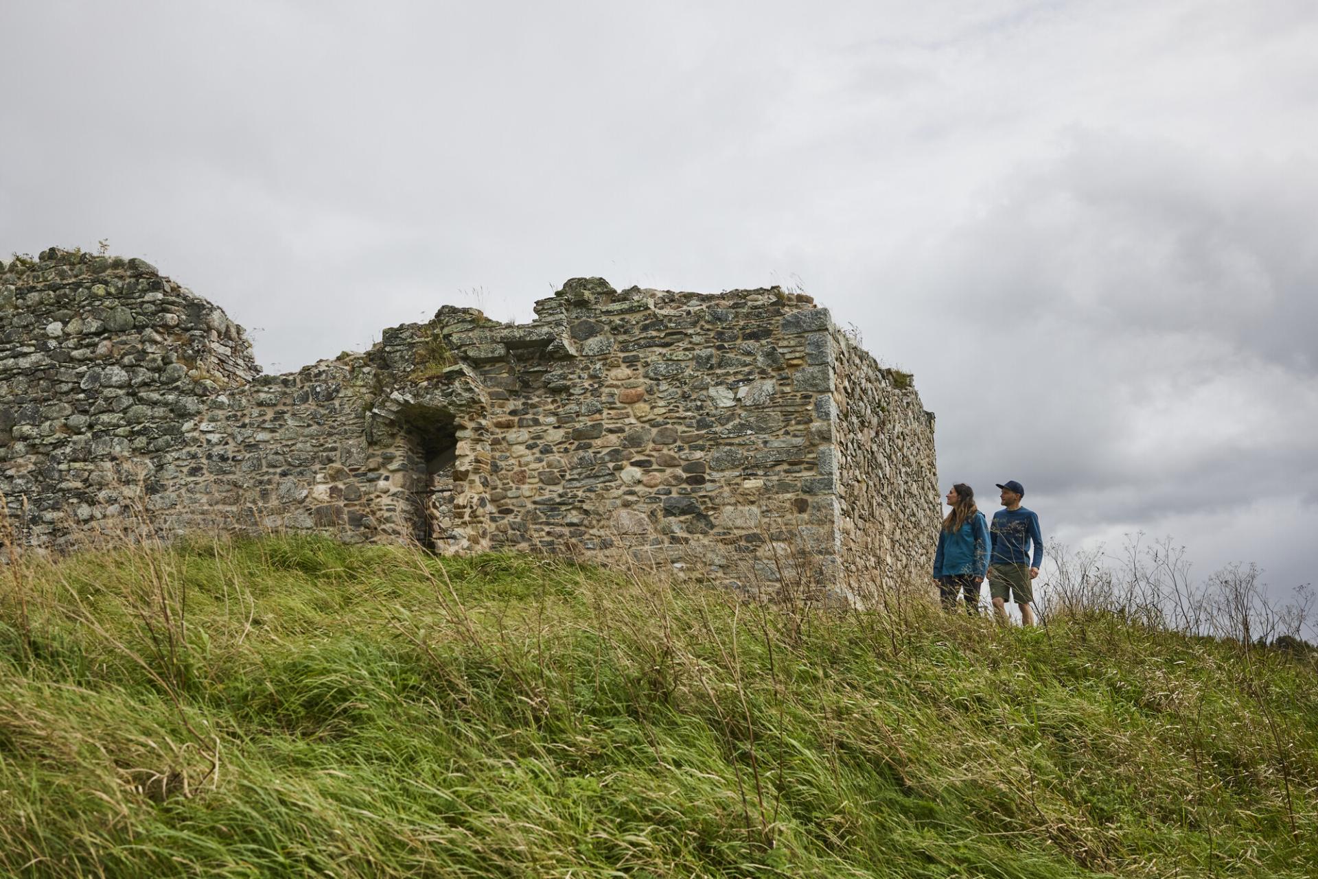 Two people explore Castle Roy in the Cairngorms National Park