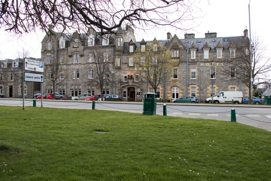 The Grant Arms Hotel in Grantown-on-Spey with grass in the foreground.