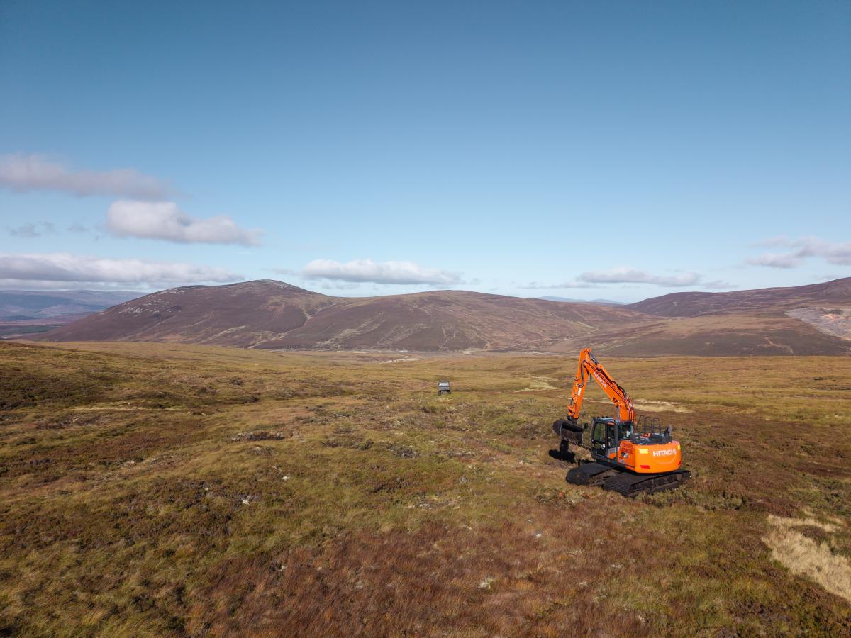 An orange digger working high up on a peatland habitat