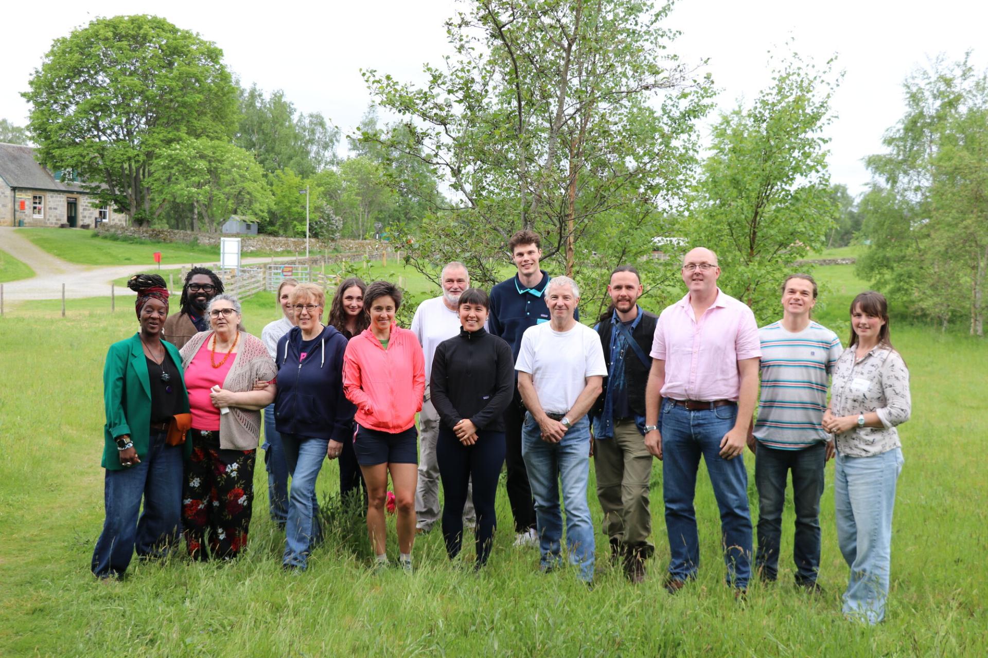 Group of people standing together on grass.