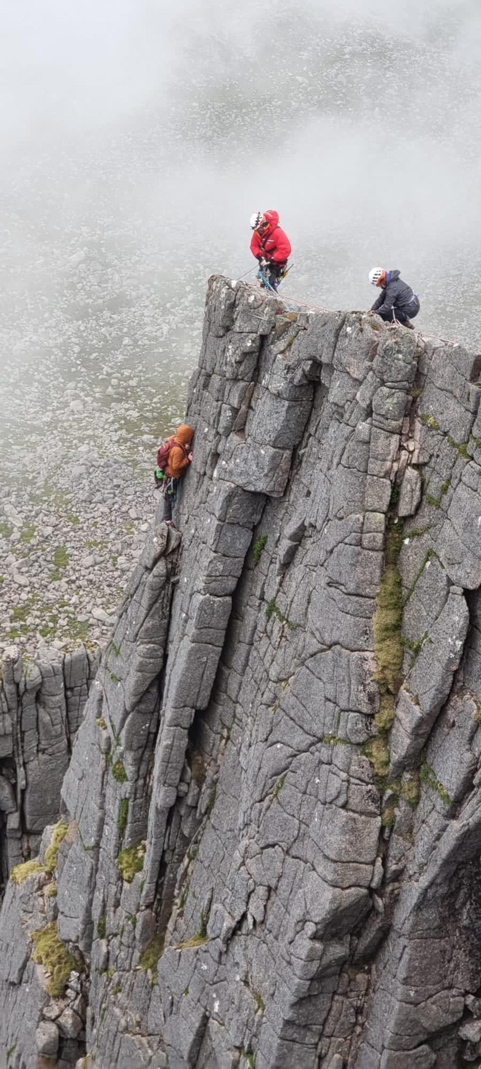 Mountain rescue volunteers descending on ropes to rescue climbers.