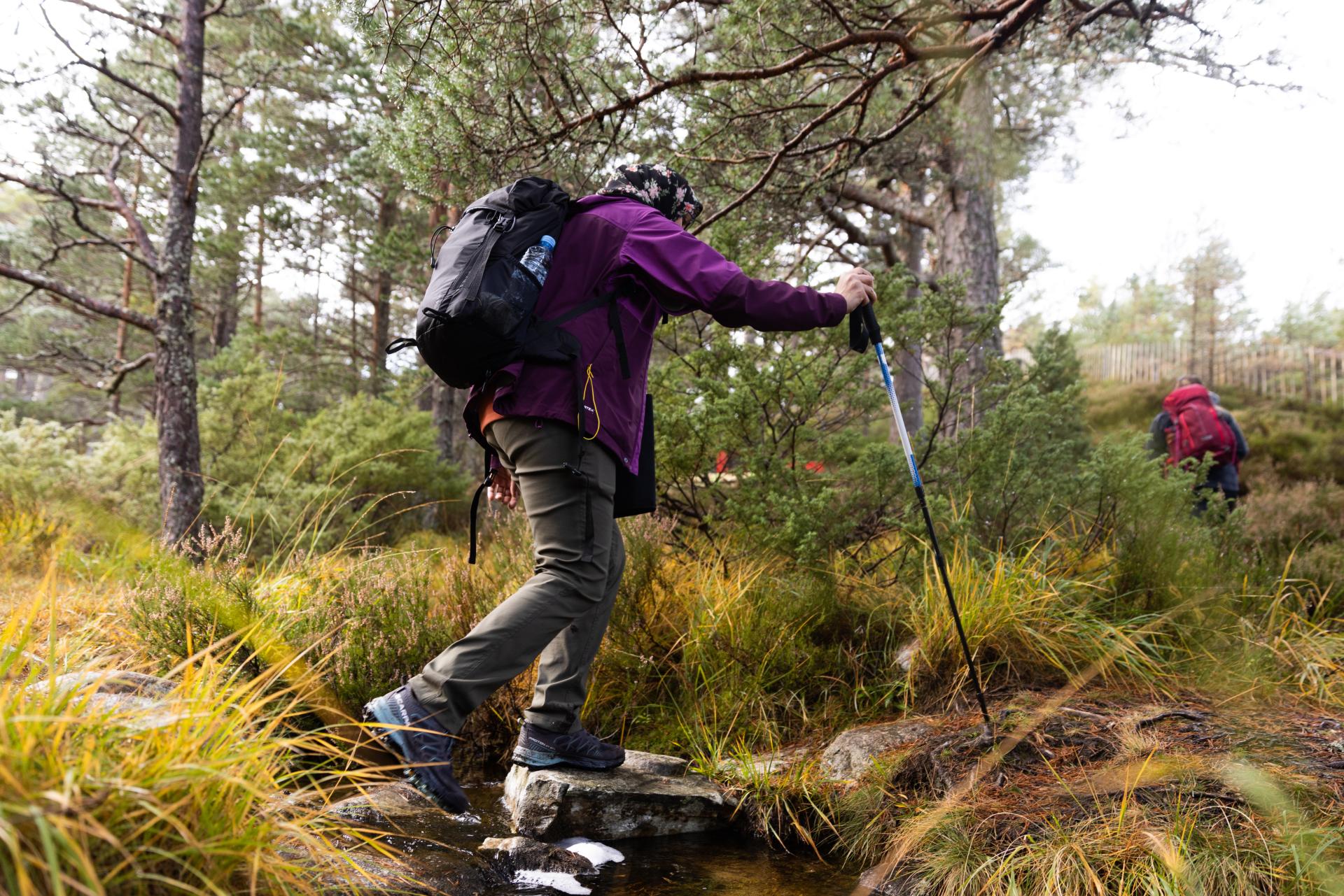 Person crossing a stream in the Cairngorms