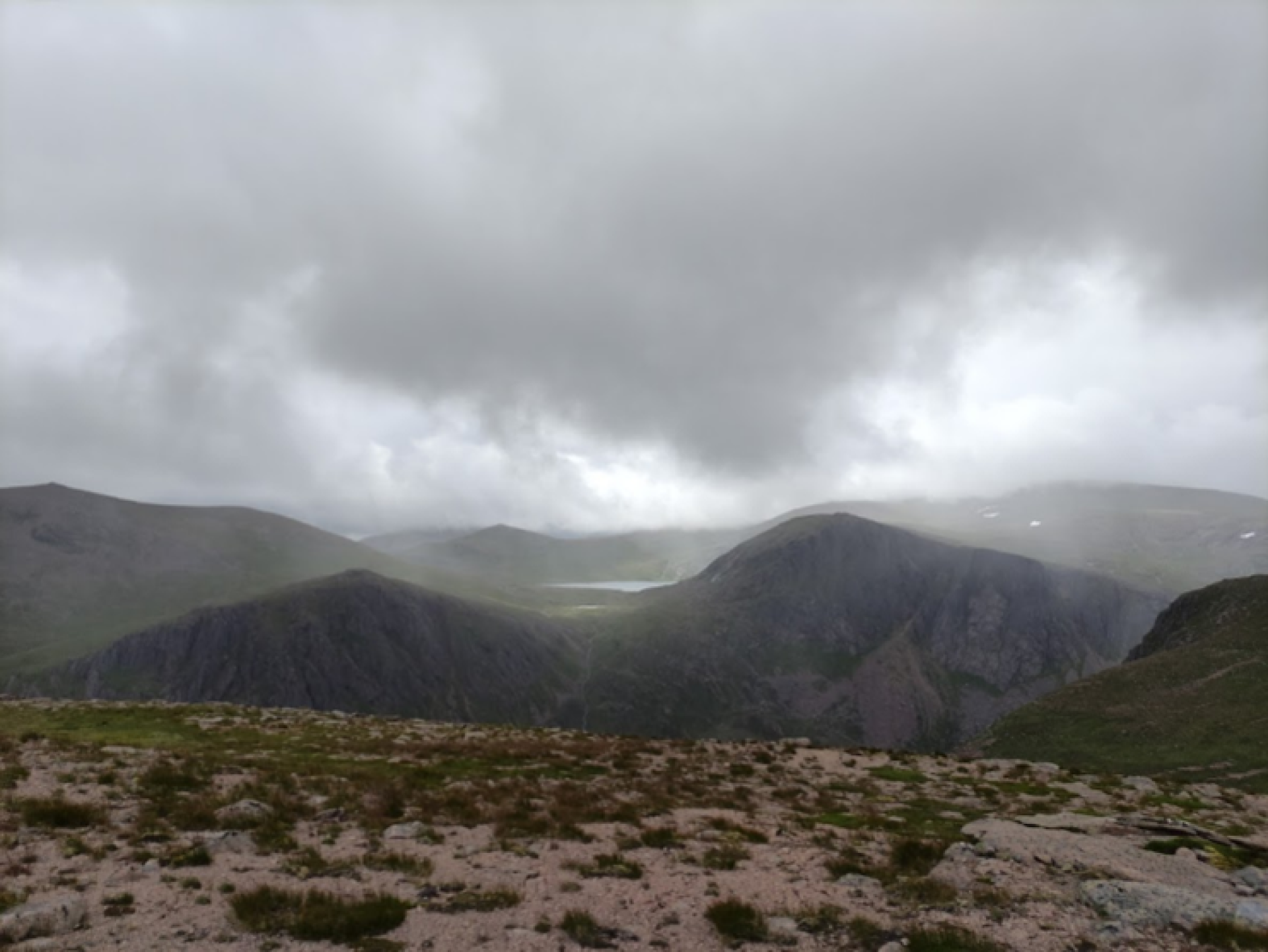 An image of mountains on a cloudy day, with low hanging grey cloud