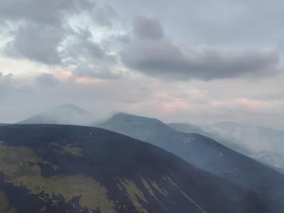 Images of hills with smoke and low cloud above.
