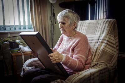 Person in chair looking at a framed photo from their day out.