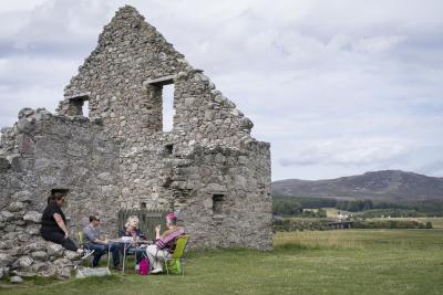 Four people around a table at Ruthven Barracks
