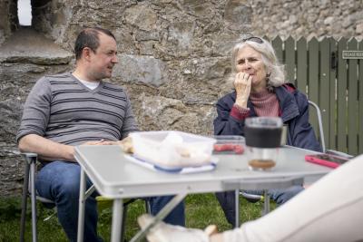 Jean and Kenny sitting at a table with food on.