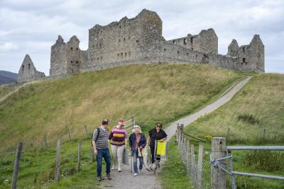 Four people walking away from Ruthven Barracks