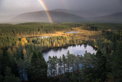 Three lochans with dark skies and a rainbow in the distance