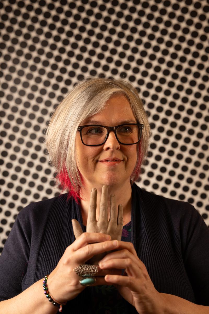 Person holding a ceramic hand.