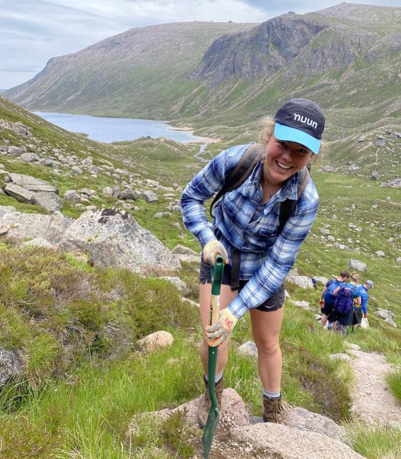 Volunteer with a shovel working on maintaining mountain paths.