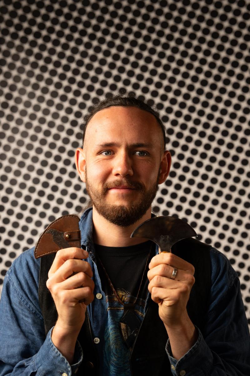 Male holding round knives.