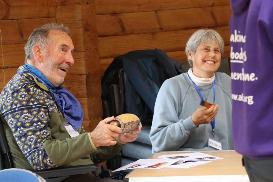 A couple with smiling faces playing instruments