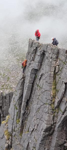 Mountain rescue volunteers descending on ropes to rescue climbers.