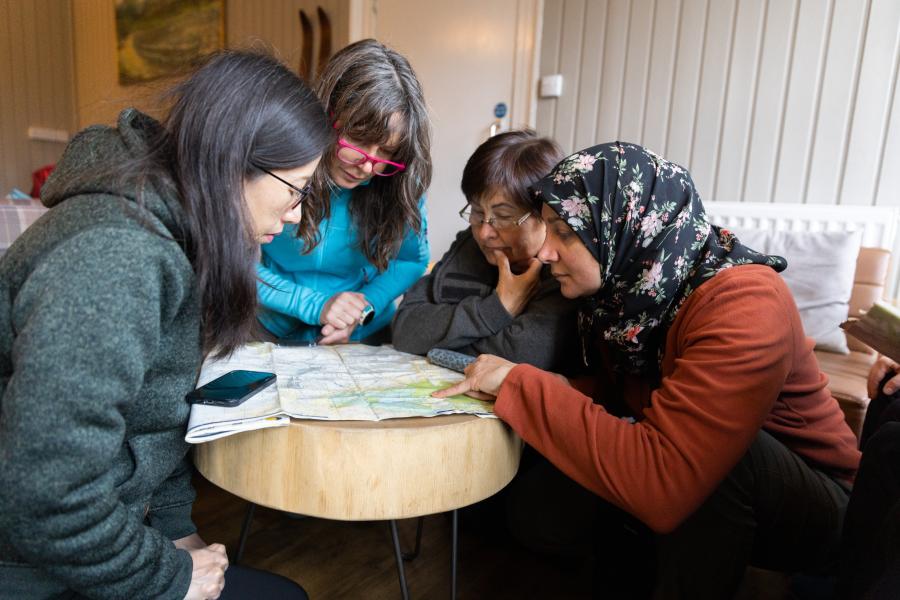Four people looking at a map around a table.