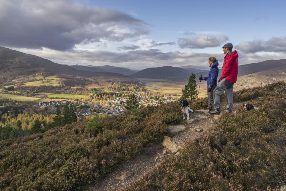 Two hillwalkers and their dogs enjoy the Braemar countryside.
