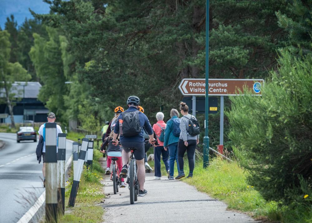Cyclists and walkers on a tarmac section of the Old Logging Way
