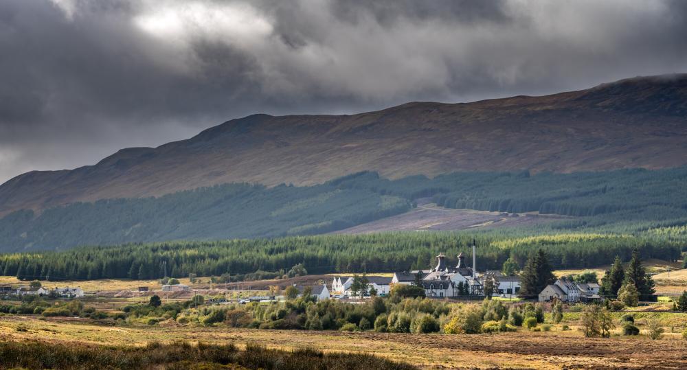 Dalwhinnie distillery and surrounding forests and mountains.