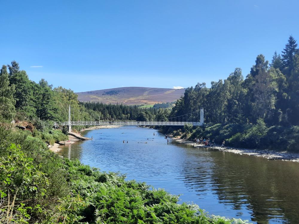 Cambus o May bridge across the River Dee with people swimming below it.