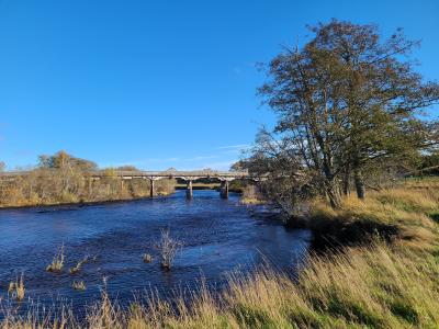 The Broomhill Bridge across the River Spey under blue sky.