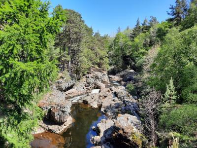 The Falls of Truim with rocky banks and trees on either side.