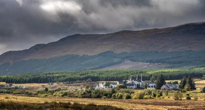Dalwhinnie distillery and surrounding forests and mountains.