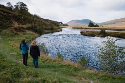 Two people o the banks of the River Dee.