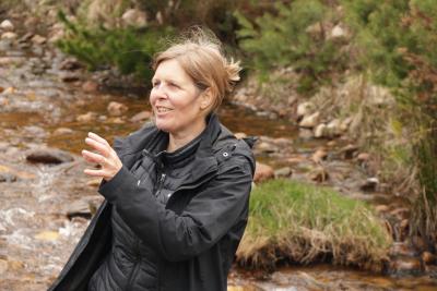 Person standing talking with river in background