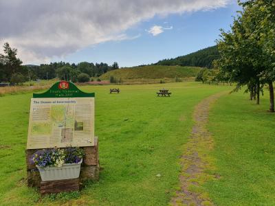 Information board for the Doune of Invernochty in grassy park.