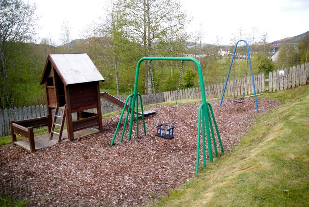 play park showing two swings and a slide.