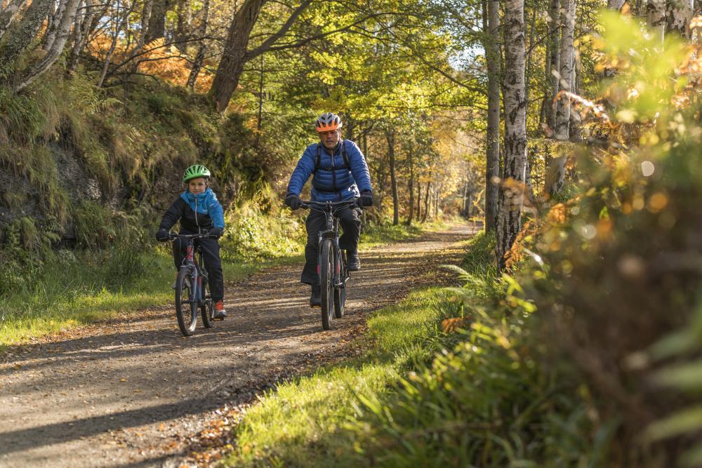 A father and son cycling a country path, Ballater