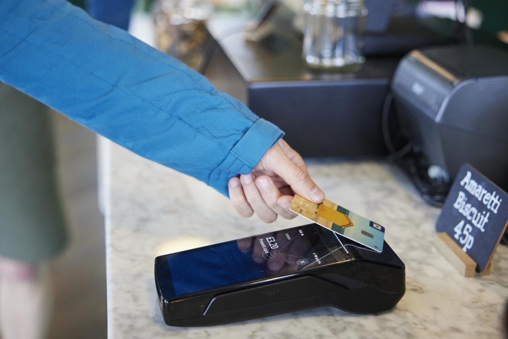 A person pays with cash at a coffee shop in the Cairngorms National Park