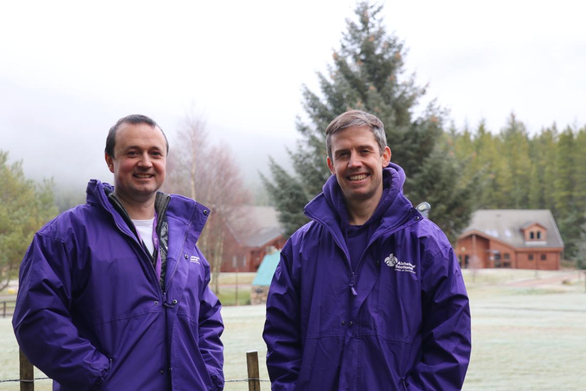 Two staff members from the Outdoor Dementia Resource Centre wearing purple jackets.