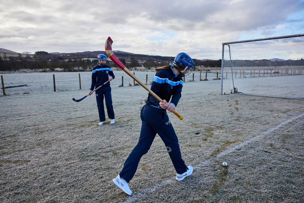 Two shinty players training on a frosty pitch at the Dell in Kingussie