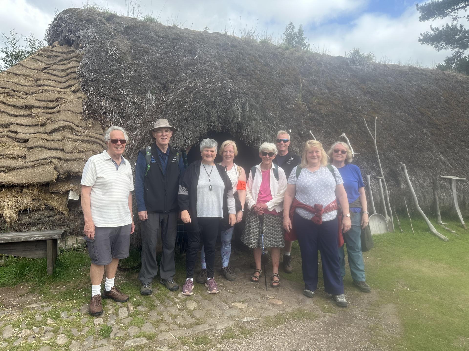 A group of people on a Health walk, standing outside a building at the Highland Folk Museum in Newtonmore.