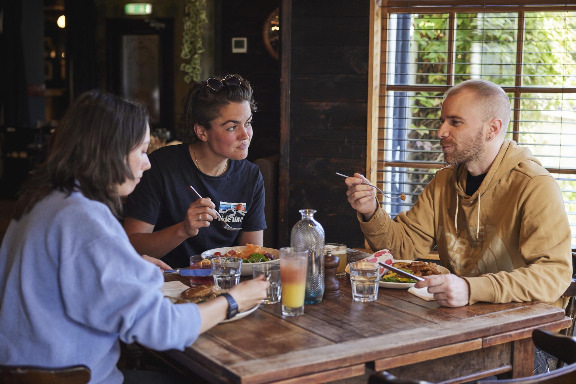 Three people enjoy a meal in a restaurant in the Cairngorms National Park.