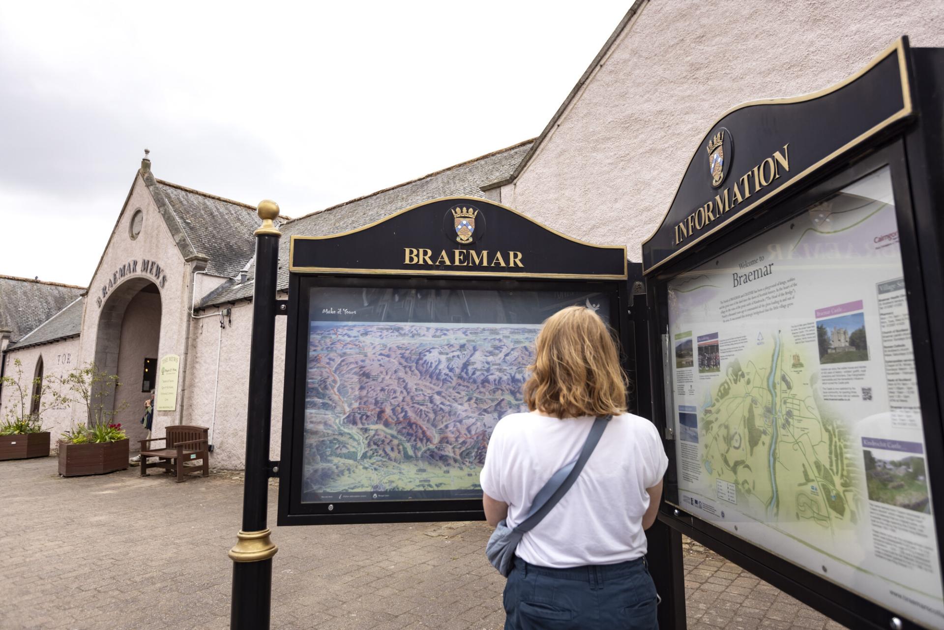A person looking at a map on the Braemar public information board