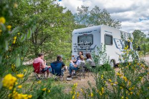 People sat on camping chairs next to a campervan in the National Park