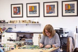 Artist Mahri Prince working on a piece of textile art in her studio