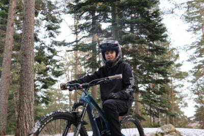Person on bike in forest snow on ground