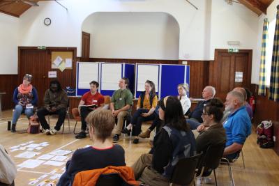 A circle of people talking and listening inside a hall